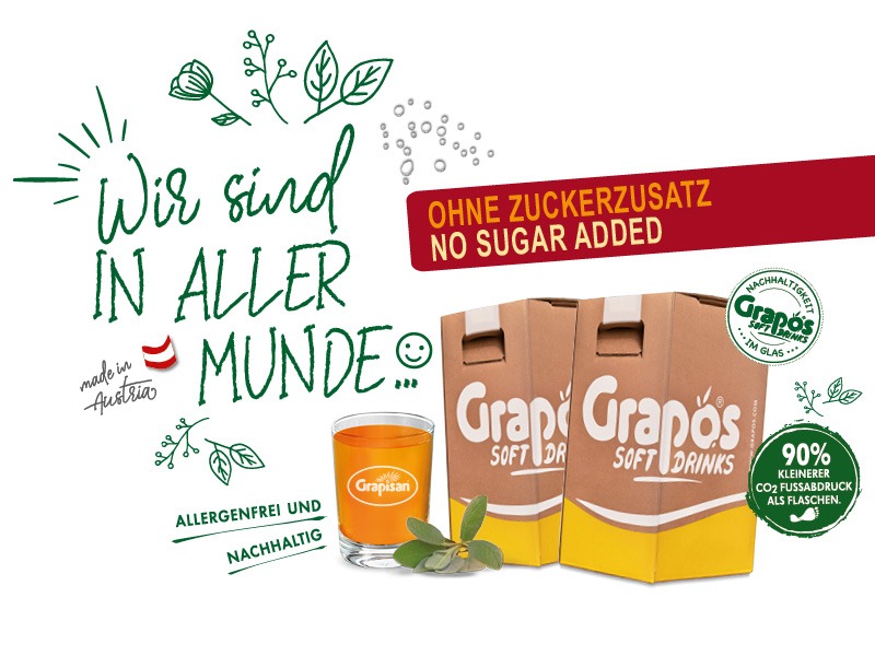 Schön dekoriertes geflltes Grapisan Glas mit zwei Verpackungen daneben und dem Hinweis ohne Zuckerzusatz sowie 90% kleinerer CO2 Fußabdruck als Flaschen